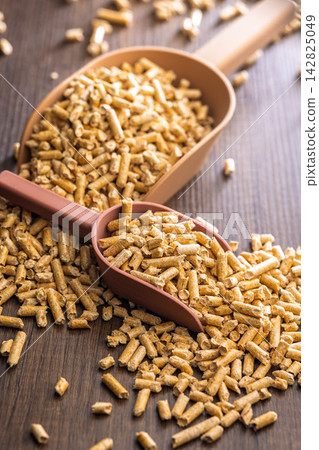 Wood Pellets Fuel Biomass in Scoops on Wooden Table for Heating and Energy Use Wood Pellets Fuel Biomass in Scoops on Wooden Table for Heating and Energy Use 142825049