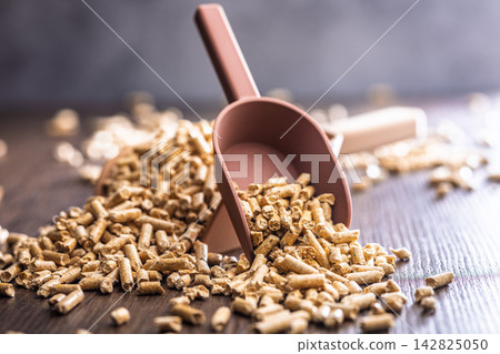 Wood Pellets Fuel Biomass in Scoops on Wooden Table for Heating and Energy Use Wood Pellets Fuel Biomass in Scoops on Wooden Table for Heating and Energy Use 142825050