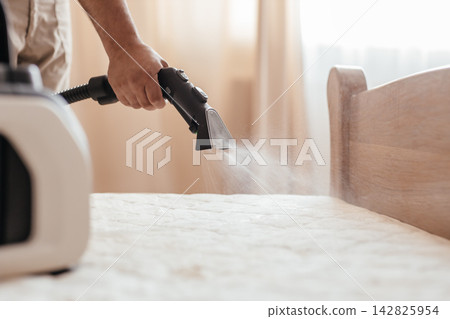 Professional steam cleaning and sanitizing mattress with extraction vacuum cleaner at home Professional steam cleaning and sanitizing mattress with extraction vacuum cleaner at home 142825954