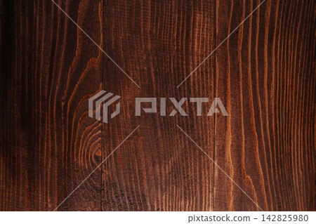Dark brown wooden surface with visible grain patterns and texture, suitable for backgrounds, furniture design, or interior decoration projects Dark brown wooden surface with visible grain patterns and texture, suitable for backgrounds, furniture design, or interior decoration projects 142825980