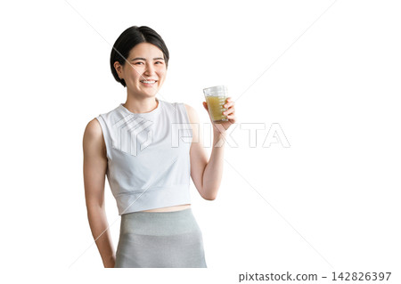 一位年輕的亞洲女性在訓練後補充水分和營養。 一位年輕的亞洲女性在訓練後補充水分和營養。 142826397