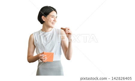 Young Asian woman in yoga wear eating a protein/nutrition bar 142826405
