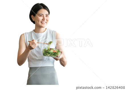 A young woman in sportswear eating a diet menu A young woman in sportswear eating a diet menu 142826408