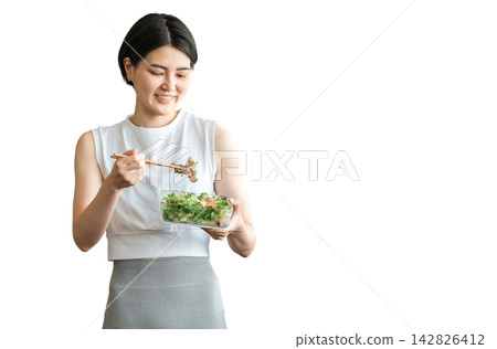 A young woman in sportswear eating a diet menu A young woman in sportswear eating a diet menu 142826412