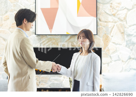 一位女商人面帶微笑地看著我,與我握手,表示一筆商業交易圓滿完成。 一位女商人面帶微笑地看著我,與我握手,表示一筆商業交易圓滿完成。 142826690