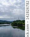 Fluffy clouds and their reflection on the lake surface. Nunome Dam. 35mm. Copy space above. Vertical composition, center of the lake. Suitable for B0 poster. 142826782