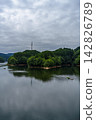 Lake surface stretching into the distance, reflecting the sky; Nunome Dam; 35mm; Copy space above; Vertical composition; Transmission tower on the left; Suitable for B0 poster. 142826789