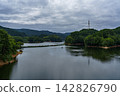 A wide lake surface reflecting the sky; Nunome Dam; 35mm; blank copy space above; horizontal composition; transmission tower on the right; suitable for B0 poster. 142826790