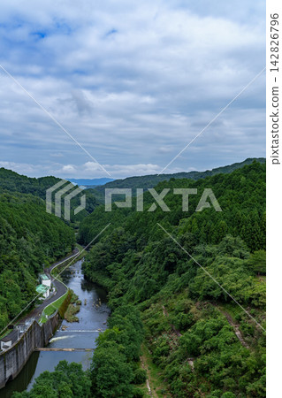 Blue sky between clouds and the flowing Nunome River at Nunome Dam. 35mm. Blank copy space at the top. Vertical composition, left edge of the river. Suitable for B0 poster. Blue sky between clouds and the flowing Nunome River at Nunome Dam. 35mm. Blank copy space at the top. Vertical composition, left edge of the river. Suitable for B0 poster. 142826796
