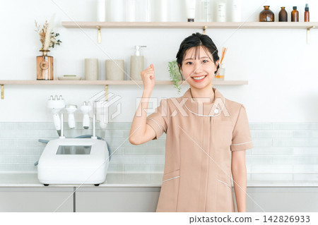 一位美容師面帶微笑，做出得意的手勢。她是美容院裡積極樂觀的女員工。 142826933