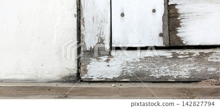 Weathered old wooden window frames and walls with peeling white paint. Weathered old wooden window frames and walls with peeling white paint. 142827794