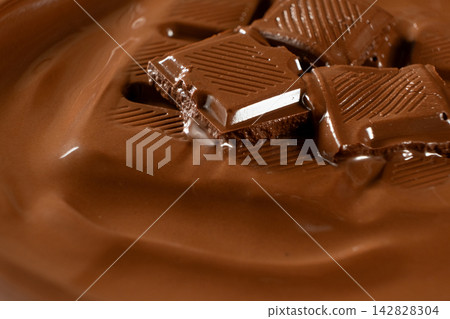 Chocolate bar pieces melting into smooth warm liquid chocolate macro shot Chocolate bar pieces melting into smooth warm liquid chocolate macro shot 142828304