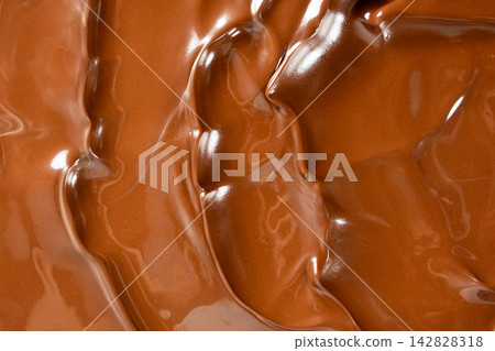 Swirling melted milk chocolate background with glossy wave texture Swirling melted milk chocolate background with glossy wave texture 142828318