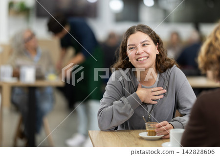 Portrait of young girl sitting at table and meeting with middle-age man over dinner in restaurant Portrait of young girl sitting at table and meeting with middle-age man over dinner in restaurant 142828606