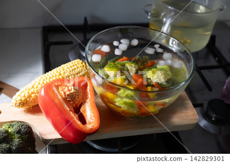 Cooling blanched vegetables in an ice water bath on a kitchen counter Cooling blanched vegetables in an ice water bath on a kitchen counter 142829301