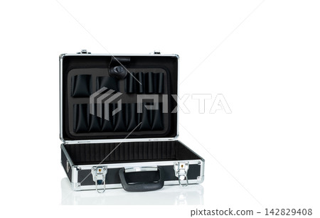 Open empty aluminum toolbox with black interior compartments isolated on white background, portable storage case designed to organize, protect and carry professional tools and equipment. Open empty aluminum toolbox with black interior compartments isolated on white background, portable storage case designed to organize, protect and carry professional tools and equipment. 142829408