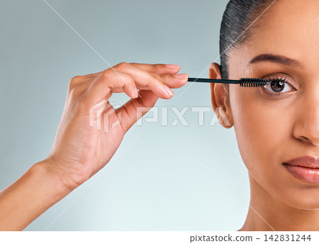 Beauty, portrait and woman with mascara brush in studio for makeup, cosmetics or curling lashes on white background. Closeup, half face and young model with product for eyes, grooming or glamour Beauty, portrait and woman with mascara brush in studio for makeup, cosmetics or curling lashes on white background. Closeup, half face and young model with product for eyes, grooming or glamour 142831244