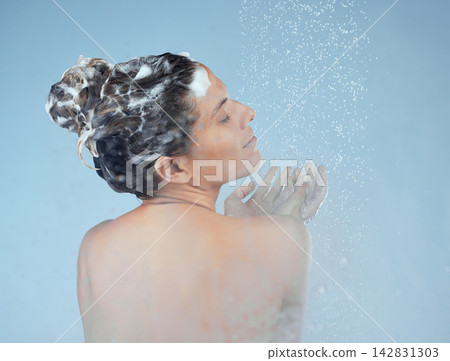 Girl, shower and shampoo in studio for hair care with organic, eco friendly cosmetic and soap for treatment. Woman, isolated and blue background for hygiene with back, water and calm with eyes closed Girl, shower and shampoo in studio for hair care with organic, eco friendly cosmetic and soap for treatment. Woman, isolated and blue background for hygiene with back, water and calm with eyes closed 142831303