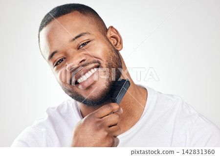 Black man, portrait and beard brush in studio for hair grooming or healthy hygiene, white background or self care. Male person, face and comb tool or morning routine for beauty, maintenance or smile Black man, portrait and beard brush in studio for hair grooming or healthy hygiene, white background or self care. Male person, face and comb tool or morning routine for beauty, maintenance or smile 142831360