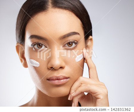 Sunscreen, cream and portrait of woman for skincare and dermatology in studio background. Calm, girl and apply lotion moisturizer on face for healthy glow or self care in beauty with cosmetics 142831362