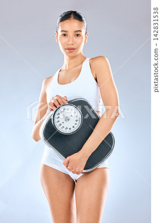 Girl, studio and portrait with scale for weightloss tracking, progress and weighing for health or nutrition for slim body. Woman, isolated and white background for fitness goal, target and measure. Girl, studio and portrait with scale for weightloss tracking, progress and weighing for health or nutrition for slim body. Woman, isolated and white background for fitness goal, target and measure. 142831538