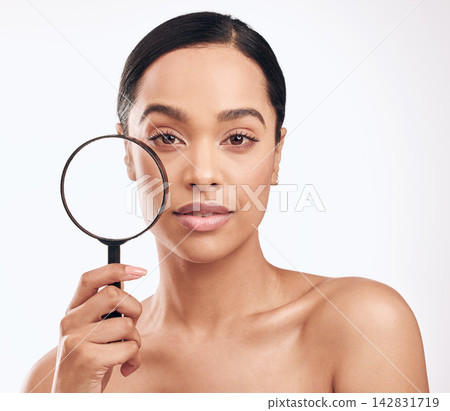 Beauty, magnifying glass and portrait of woman in studio isolated on white background. Cosmetics, investigation or skincare and confident model search for dermatology, wellness routine and check face Beauty, magnifying glass and portrait of woman in studio isolated on white background. Cosmetics, investigation or skincare and confident model search for dermatology, wellness routine and check face 142831719
