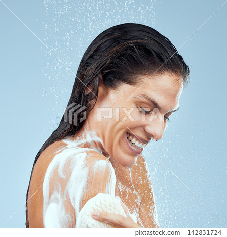 Woman, shower and sponge for skincare in studio, cleaning and soap for cosmetics or hygiene. Female person, exfoliate and foam for grooming on blue background, beauty and liquid for routine scrub Woman, shower and sponge for skincare in studio, cleaning and soap for cosmetics or hygiene. Female person, exfoliate and foam for grooming on blue background, beauty and liquid for routine scrub 142831724