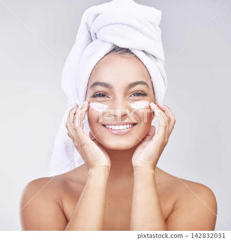 Happy woman, portrait and skincare with cream for facial treatment, hygiene or beauty on a gray studio background. Face of young female person or model with smile, anti aging ointment or healthy skin 142832031