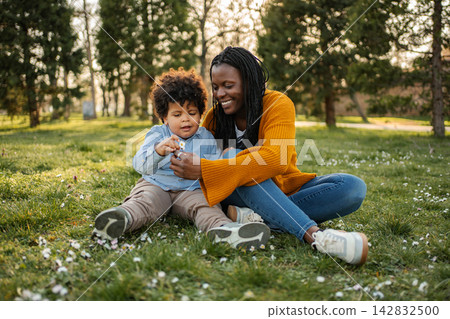 Mother and child bonding in a park discovering nature Mother and child bonding in a park discovering nature 142832500