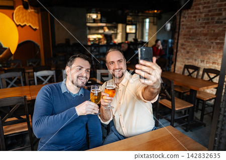 Friends taking selfie at the bar and drinking beer Friends taking selfie at the bar and drinking beer 142832635