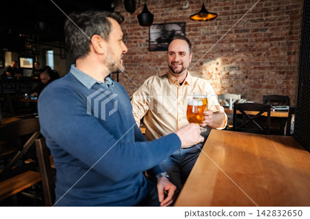 Friends toasting beer glasses enjoying pub night Friends toasting beer glasses enjoying pub night 142832650