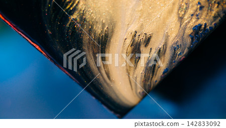 Glitter paint. Fluid art. Defocused yellow blue color shiny triangle blend sparkling texture spilling on abstract background. Glitter paint. Fluid art. Defocused yellow blue color shiny triangle blend sparkling texture spilling on abstract background. 142833092