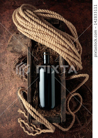 Dark glass bottle of hard liquor in a vintage wooden box. Dark glass bottle of hard liquor in a vintage wooden box. 142833111