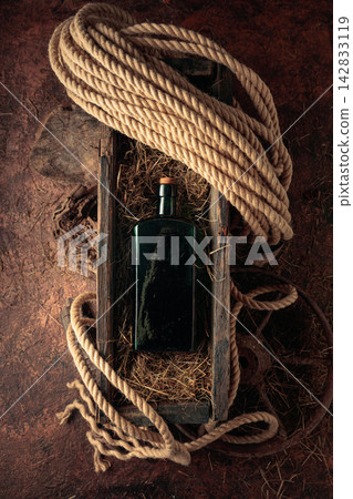 An antique bottle of hard liquor in a vintage wooden box. An antique bottle of hard liquor in a vintage wooden box. 142833119