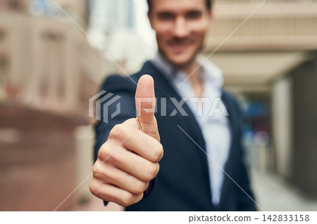 Businessman, hand and vote with thumbs up in city for review, winning or business success. Closeup of man or employee with like emoji, yes sign or OK in approval or positive feedback in an urban town Businessman, hand and vote with thumbs up in city for review, winning or business success. Closeup of man or employee with like emoji, yes sign or OK in approval or positive feedback in an urban town 142833158