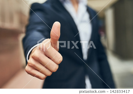 Businessman, hand and review with thumbs up in city for vote, winning or business success. Closeup of man or employee with like emoji, yes sign or OK in approval or positive feedback in an urban town Businessman, hand and review with thumbs up in city for vote, winning or business success. Closeup of man or employee with like emoji, yes sign or OK in approval or positive feedback in an urban town 142833417