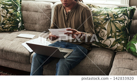 Paperwork, laptop and man sitting on sofa in home for finance, accounting and debt in living room. Computer, documents and online for insurance, bills and overdue payment with budget in apartment Paperwork, laptop and man sitting on sofa in home for finance, accounting and debt in living room. Computer, documents and online for insurance, bills and overdue payment with budget in apartment 142833920