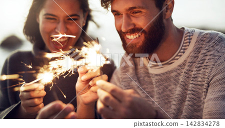 Happy, couple and fireworks sparkle at celebration with happiness on holiday or vacation in summer. Fire, sparks and people excited for countdown to new year at party or event outdoor with glow stick Happy, couple and fireworks sparkle at celebration with happiness on holiday or vacation in summer. Fire, sparks and people excited for countdown to new year at party or event outdoor with glow stick 142834278