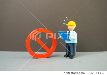 An engineer with blueprints surprised by a large prohibition symbol. Construction ban, moratorium on land works. Concept of regulation, restriction and project delay risk. An engineer with blueprints surprised by a large prohibition symbol. Construction ban, moratorium on land works. Concept of regulation, restriction and project delay risk. 142834332