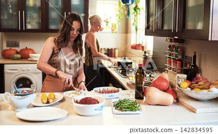 Young woman, cooking and preparing with ingredients in kitchen for meal, lunch or dinner on table at home. Female person or friends helping or getting ready for supper, brunch or eating at house Young woman, cooking and preparing with ingredients in kitchen for meal, lunch or dinner on table at home. Female person or friends helping or getting ready for supper, brunch or eating at house 142834595