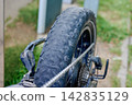 Damaged electric bicycle wheel with bald rubber tread 142835129