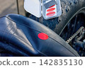 A person is applying a red patch to a bicycle tire using a repair kit on a sunny day in an outdoor setting 142835130