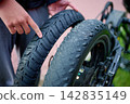 Man pointing at new road tire replacing old fatbike rubber 142835149