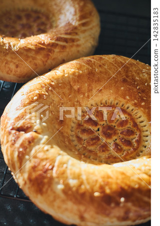 Fresh Uzbek non bread with sesame seeds on cooling rack Fresh Uzbek non bread with sesame seeds on cooling rack 142835183