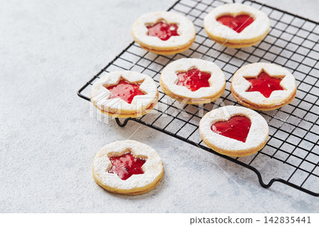 Classic Linzer Christmas Cookies with raspberry or strawberry jam on light background. Classic Linzer Christmas Cookies with raspberry or strawberry jam on light background. 142835441