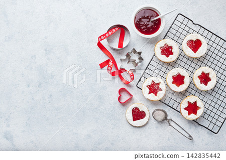 Classic Linzer Christmas Cookies with raspberry or strawberry jam on light background. Classic Linzer Christmas Cookies with raspberry or strawberry jam on light background. 142835442