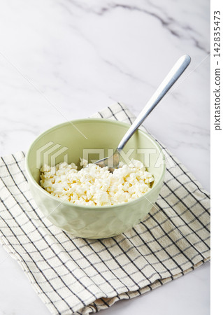Cottage cheese in bowl on white background Cottage cheese in bowl on white background 142835473