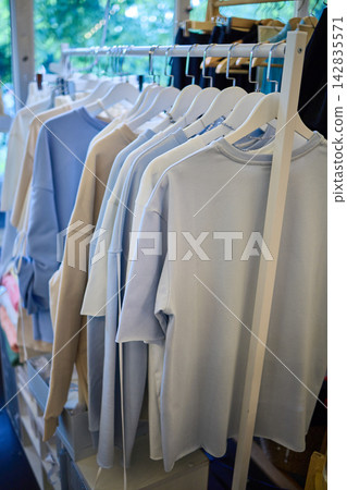 Neutral Color Clothing on Hangers in Boutique Display Neutral Color Clothing on Hangers in Boutique Display 142835571