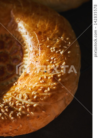 Traditional Uzbek non bread with sesame seeds close-up Traditional Uzbek non bread with sesame seeds close-up 142835578