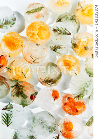 Frozen Ice Balls with Sea Buckthorn Berries and Evergreen Branches Frozen Ice Balls with Sea Buckthorn Berries and Evergreen Branches 142835874